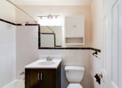 Thumbnail 6 of 28 - bathroom with tub, toilet, vanity, medicine cabinet and mirror at the norwood apartments in adams morgan washington dc