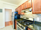 Thumbnail 3 of 26 - kitchen with oak cabinetry, tile flooring and stainless steel appliances at 2701 connecticut apartments in washington dc