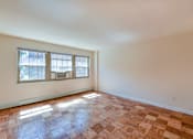 Thumbnail 10 of 16 - vacant living area with large windows and hardwood floors at alpha house apartments in washington dc