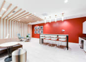 Thumbnail 16 of 21 - resident lounge with social seating, tables, and catering kitchen at archer park apartments in southeast Washington dc