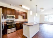 Thumbnail 3 of 21 - kitchen with island, stainless steel appliances and hardwood flooring at archer park apartments in southeast Washington dc