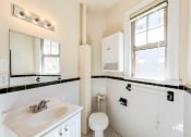 Thumbnail 11 of 29 - bathroom with toilet, sink, vanity, mirror and cabinet at the frontenac apartments in van ness washington dc