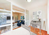 Thumbnail 7 of 20 - bedroom with bed, desk, hardwood flooring, large windows and a view of living area at baystate apartments washington dc