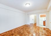 Thumbnail 9 of 20 - vacant living area with hardwood floors and view of kitchen  at baystate apartments in washington dc