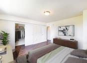 Thumbnail 7 of 18 - a bedroom with a bed and a dresser and a closet