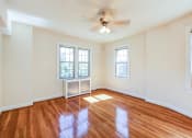 Thumbnail 21 of 29 - vacant bedroom with hardwood floors, ceiling fan and large windows at the frontenac apartments in van ness washington dc