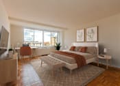 Thumbnail 22 of 47 - A modern bedroom with a large bed and a television.