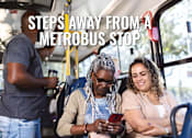 Thumbnail 16 of 16 - A group of people are sitting on a bus with the text "Steps Away From A Metrobus Stop" overlaid on the image.