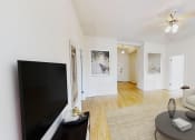 Thumbnail 6 of 25 - living area with sofa, coffee table, credenza, tv, hardwood floors and ceiling fan at the calverton aparbments in washington dc