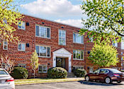 Thumbnail 1 of 24 - A red brick building with a white door and windows.