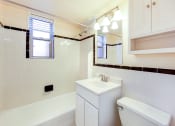Thumbnail 14 of 23 - bath room with view of toilet, vanity, tub, and window at cambridge square apartments in bethesda md