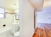 Thumbnail 13 of 23 - bathroom with window, tub, toilet, vanity and view of living area at cambridge square apartments in bethesda md