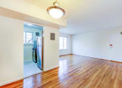 Thumbnail 17 of 23 - vacant living area with large windows, hard wood flooring and view of kitchen in cambridge square apartments in bethesda md