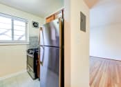 Thumbnail 4 of 23 - kitchen with stainless steel appliances and wood cabinetry at cambridge square apartments in bethesda md