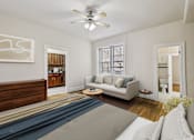 Thumbnail 13 of 32 - A living room with a couch, a coffee table, and a ceiling fan.