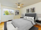 Thumbnail 15 of 24 - bedroom with wood flooring, bed, night stands, ceiling fan, and large windows at chillum place apartments in washington dc