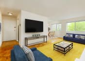 Thumbnail 9 of 24 - living area with wood flooring, sofa, love seat, coffee table, tv and large windows at chillum place apartments in washington dc