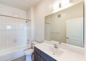 Thumbnail 18 of 18 - bathroom with large mirror, tub, toilet and vanity at city view apartments in washington dc