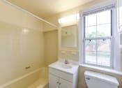 Thumbnail 12 of 21 - bathroom with vanity, mirror, tub, toilet and window at colonnade apartments in washington dc