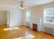 Thumbnail 12 of 18 - vacant living area with large windows, firelplace and ceiling fan at 4031 davis apartments in washington dc