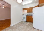 Thumbnail 2 of 17 - kitchen with oak cabinetry, tile flooring and white appliances at 1400 van buren apartments in washington dc