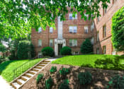 Thumbnail 1 of 17 - exterior of 1400 van buren apartments with lush landscaping, brick building and sidewalk
