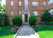 Thumbnail 12 of 17 - exterior of 1400 van buren apartments with lush landscaping, brick building and sidewalk