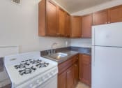 Thumbnail 9 of 21 - kitchen with refrigerator, gas range and tile flooring at 6100 14th Street apartments in washington dc
