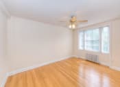 Thumbnail 14 of 21 - vacant living area with hardwood flooring, large windows and ceiling fan at 6100 14th Street apartments in washington dc