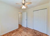 Thumbnail 13 of 16 - vacant bedroom with hardwood flooring, large closets, and ceiling fan at alpha house apartments in washington dc
