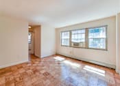 Thumbnail 12 of 16 - vacant living area with hardwood floors, large windows and view of hallway at alpha house apartments in washington dc