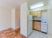 Thumbnail 8 of 16 - kitchen with tile floor, wood cabinetry, gas stove and energy efficient appliances at alpha house apartments in washington dc