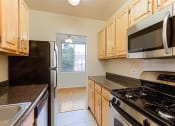 Thumbnail 19 of 47 - kitchen with stainless steel appliances, and view of dining area with hardwood floors at brunswick house apartments in dupont circle washington dc