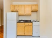 Thumbnail 16 of 47 - kitchen with light oak cabinetry, stove, refrigerator and sink at brunswick house apartments in dupont circle washington dc