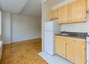 Thumbnail 17 of 47 - kitchen with light oak cabinetry, stove, refrigerator, sink, and view of living area at brunswick house apartments in dupont circle washington dc