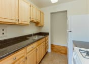 Thumbnail 5 of 24 - kitchen with tile flooring, refrigerator, gas stove and  oak cabinetry at chillum place apartments in lamond riggs washington dc