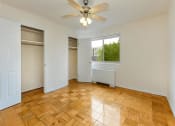 Thumbnail 12 of 24 - vacant bedroom with hardwood flooring, view of closets, windows, and ceiling fan at chillum place apartments in lamond riggs washington dc