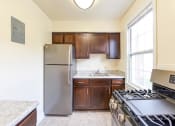 Thumbnail 2 of 21 - kitchen with espresso cabinetry, stainless steel appliances, gas range and window at the colonnade apartments in washington dc