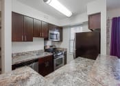 Thumbnail 2 of 25 - kitchen with espresso cabinetry, breakfast bar and window at fairway park apartments in washington dc