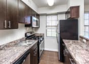 Thumbnail 3 of 25 - kitchen with espresso cabinetry, breakfast bar and window at fairway park apartments in washington dc