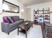 Thumbnail 7 of 25 - living area with sofa, coffee table, bookshelves, large mirror and view of front entrance at fairway park apartments in washington dc