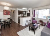 Thumbnail 6 of 25 - living area with sofa, coffee table large windows and views of dining area and kitchen at fairway park apartments in washington dc