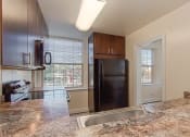 Thumbnail 5 of 21 - kitchen with espresso cabinetry, window, breakfast bar and energy efficient appliances at juniper courts apartments in takoma washington dc