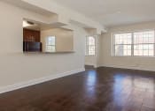 Thumbnail 12 of 21 - vacant living area with large windows, hardwood floors and view of kitchen at juniper courts apartments in takoma washington dc