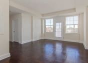 Thumbnail 14 of 21 - vacant living area with french door leading to balcony and large windows at juniper courts apartments in takoma washington dc