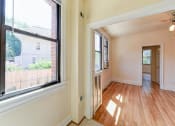 Thumbnail 22 of 28 - vacant living area with hardwood flooring and large windows at the klingle apartments in washignton dc