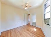 Thumbnail 24 of 28 - vacant bedroom with hardwood flooring , closet, ceiling fan and view of bathroom at the klingle apartments in washignton dc