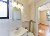 Thumbnail 12 of 28 - bathroom with vanity, mirror, toilet and view of bedroom at the klingle apartments in washignton dc