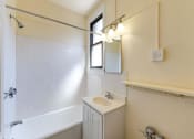 Thumbnail 11 of 28 - bathroom with tub, vanity, mirror and window at the klingle apartments in washignton dc