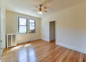 Thumbnail 16 of 28 - vacant living area with hardwood flooring, large windows and ceiling fan at the klingle apartments in washignton dc